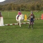 Children riding ponies learning how to to tricks