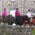 ladies riding horses throuhg the town