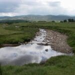 Highlands landscape shot with river cutting between the field