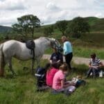 Group of people with white horse stopping for a break