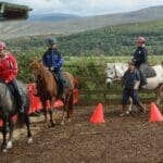 Ladies riding horse in riding area