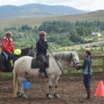 Ladies riding horse in riding area