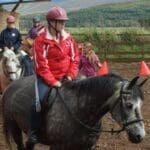 Woman on horse back in riding area